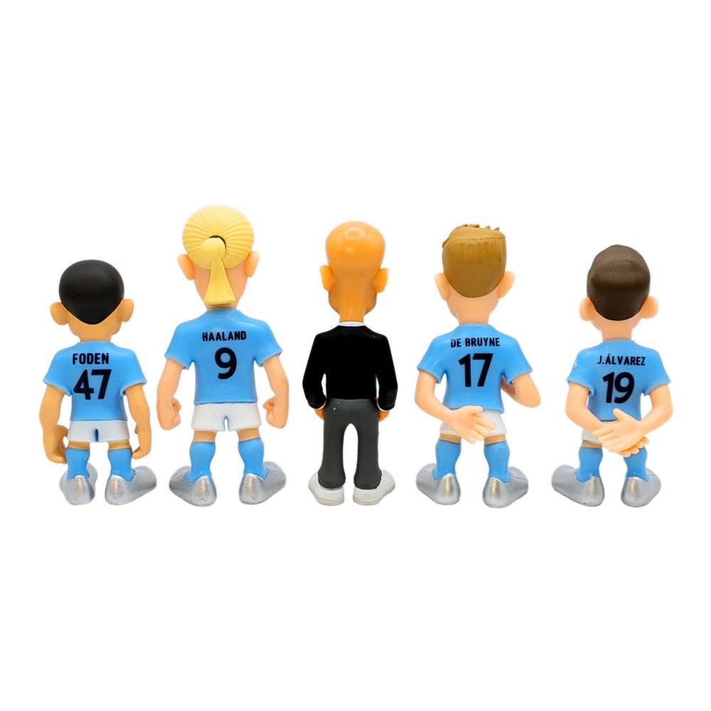 Minix Manchester City five-pack of plastic football figurines, viewed from behind in sky-blue kits, with Guardiola in black and player names and numbers.