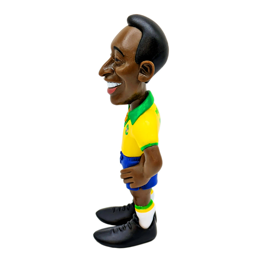 Football figurine, Minix Pelé Brazil Home Kit, wearing a yellow and green jersey, blue shorts, white socks and black boots.