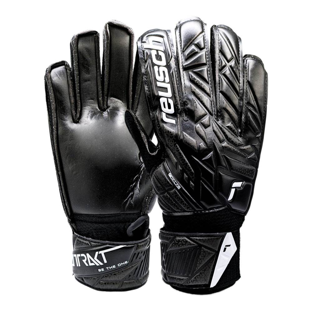 Reusch Attrakt Solid Junior Goalkeeper Gloves black with Expanse Cut palm and adjustable wrist straps designed for durability and flexibility on artificial grass.