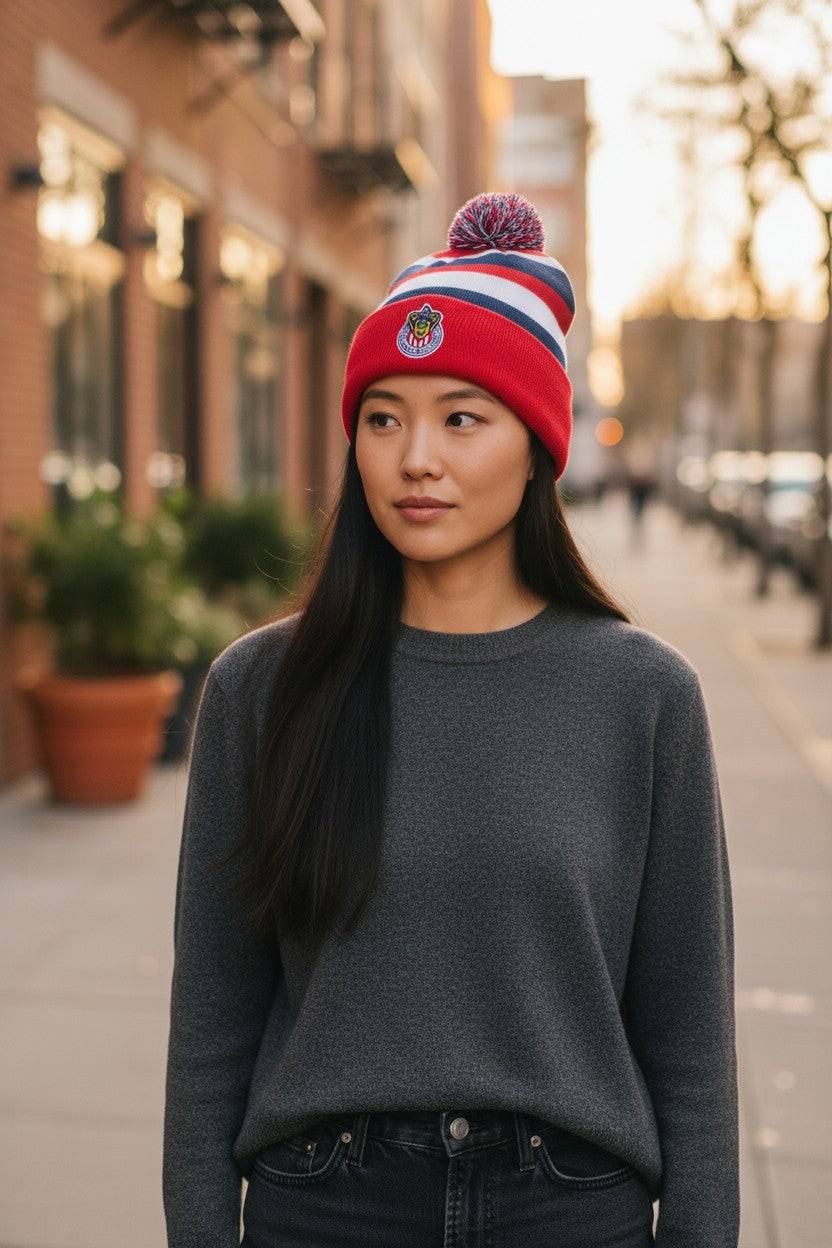 Woman wearing Fan Ink officially licensed international soccer knit cap with Chivas club crest and pom-pom on city street