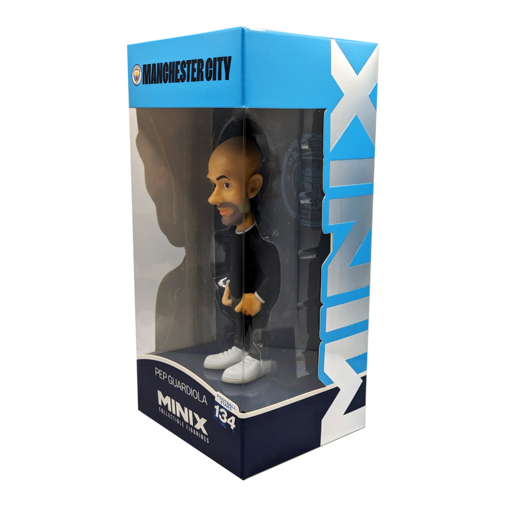 Minix Pep Guardiola Manchester City collectible figurine with a bald head, black outfit and white trainers in a blue display box.