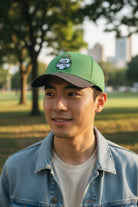 Man wearing Fan Ink officially licensed 2-tone adjustable soccer hat in green and black outdoors