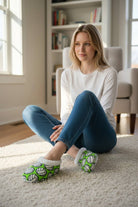 woman wearing cozy volleyball slippers with non-slip sole sitting on carpet indoors
