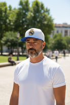 man wearing white and blue Fan Ink Dawn fitted hat outdoors on sunny day
